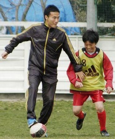 宮城県亘理町を訪れ、子どもとサッカーをする日本代表の今野泰幸選手(2011年4月11日、共同)