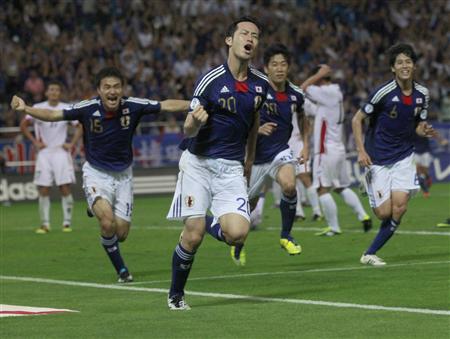サッカーW杯3次予選の日本―北朝鮮。試合終了間際に決勝ゴールを決め、ガッツポーズで駆けだす吉田(左から2人目)と喜ぶ今野(左端)ら日本イレブン=2日、埼玉スタジアム