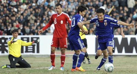 アウェーのタジキスタン戦で今野(15)が先制ゴールを決めて駆けだす。隣は香川(2011年11月11日、ドゥシャンベ、共同)