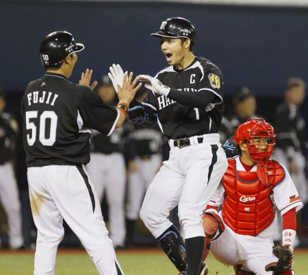 8回に勝ち越し2ランを放ち藤井彰(左)に迎えられる鳥谷。珍しく表情に生気がみなぎる。(5月8日、共同)