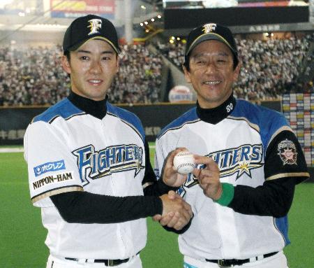 西武との今季開幕戦に快勝。ウイニングボールを手に満面に笑みの栗山新監督(右)とプロ初の完投勝利を挙げた斎藤(3月30日、札幌ドーム、共同)