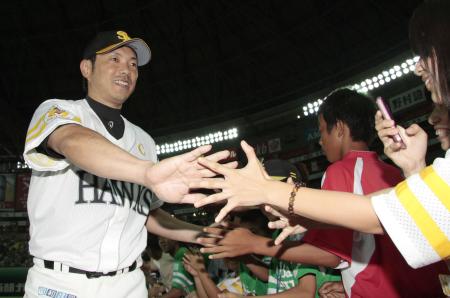 勝利の喜びを分かち合う小久(左)とファンのタッチシーン。(8月28日のオリックス戦から、共同)