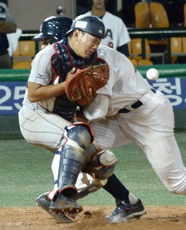 18U世界野球選手権米国戦の7回、勝ち越しの生還をした走者と交錯する捕手森=7日、ソウル(共同)
