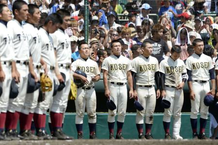 大阪桐蔭(手前)に敗れてベンチ前に整列する光星学院ナイン。またも決勝戦の後、自分たちの校歌を歌う栄誉を逃した。(8月23日、共同)