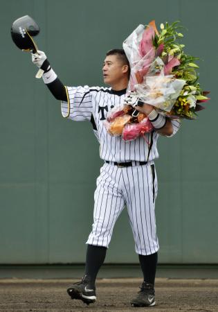引退試合となったウエスタン・リーグのオリックス戦で、花束を手にファンの声援に応える阪神・城島=9月29日、鳴尾浜(共同)