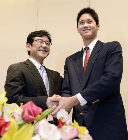 記者会見を終え、笑顔でポーズをとる花巻東高の大谷翔平投手(右)と日本ハムの栗山監督=9日夜、岩手県奥州市内のホテル