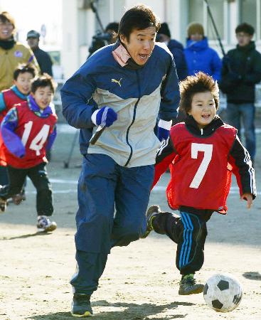 東日本大震災の復興支援を目的としたサッカー教室で、子どもたちと触れ合う中山雅史さん=12月27日、仙台市内