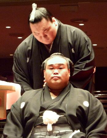 断髪式で感無量の面持ちの元十両北勝国(下)。同期生の横綱白鵬も参加しはさみを入れた(2013年2月2日、両国国技館、共同)