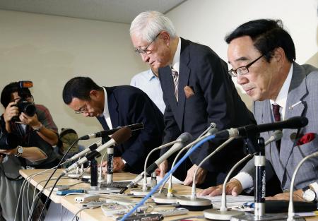 記者会見を終え引き揚げる日本野球機構の加藤良三コミッショナー(右から2人目)ら=14日午後、東京・内幸町のNPB事務局