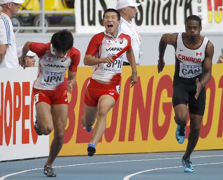 男子400メートル決勝で第2走者の藤光(左)にバトンを渡す桐生。その形相と宙を駆けるような走りが印象的(2013年8月19日、共同)