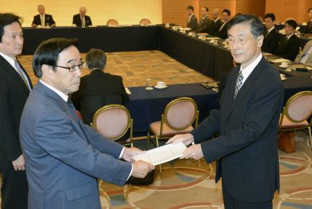 第三者委員会の那須弘平委員長(右)から、最終報告を受け取るパ・リーグ理事長の村山良雄オリックス球団本部長=27日午後、東京都港区のホテル