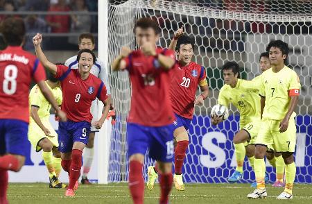 日本―韓国 後半、PKを決め喜ぶ張賢秀(20)ら韓国イレブン。右端は肩を落とす大島=仁川(共同)