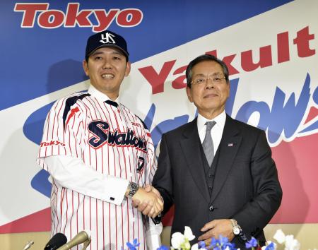 「2桁勝利は当たり前」ヤクルトの入団記者会見で衣笠球団社長(右)と握手を交わす成瀬善久投手(2014年12月9日、共同)