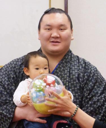 日本相撲協会のファンサービス企画で赤ちゃんを抱っこする横綱白鵬(2014年12月25日、共同)