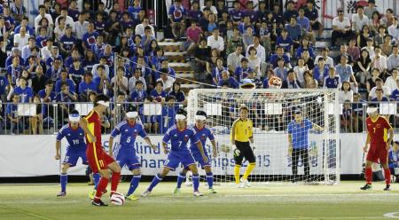 ブラインドサッカーのアジア選手権で、中国選手(手前左)をマークする日本チーム。会場となった東京・国立代々木競技場フットサルコートには大勢の観客が詰め掛けた(2015年9月2日、共同)
