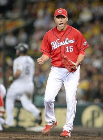阪神・ゴメスを遊ゴロ併殺に打ち取り、ガッツポーズする広島先発の黒田=甲子園(2015年10月4日、共同)