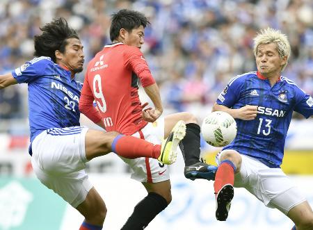 横浜M―浦和 後半、ゴール前で横浜M・中沢(左)らに突破を阻まれる浦和・武藤(中央)=日産スタジアム