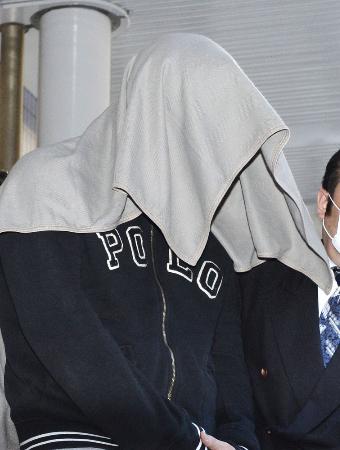 布をかぶり、移送される笠原将生容疑者=4月29日、羽田空港