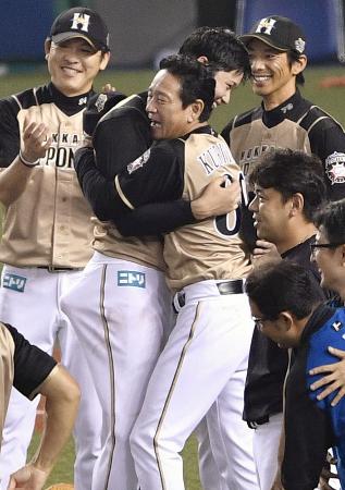 4年ぶりのパ・リーグ優勝を決め、抱き合い喜ぶ日本ハム・大谷(中央左)と栗山監督=西武プリンスドーム