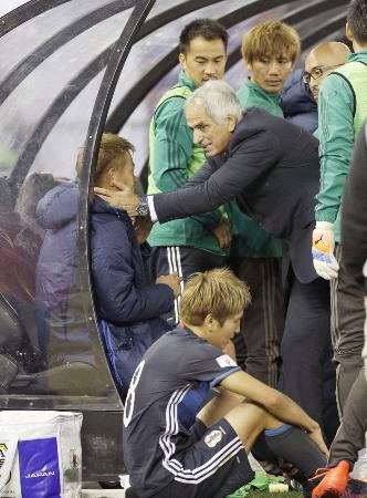 試合後、本田(左)に声を掛けるハリルホジッチ監督。下は原口=メルボルン(共同)