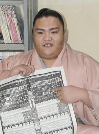 大相撲九州場所の番付表を手にする新小結の御嶽海=10月31日、福岡県新宮町の出羽海部屋宿舎