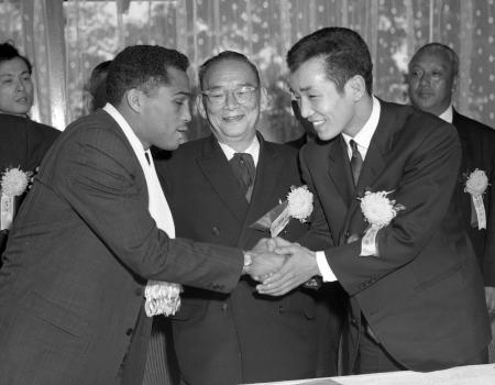 世界フェザー級タイトルマッチの調印後に握手をかわす関光徳(右)と、シュガー・ラモス=1964(昭和39)年2月12日、麻布プリンスホテル