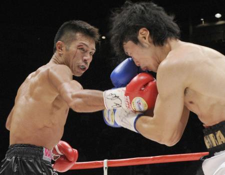 2011年1月、WBAスーパーフェザー級タイトルマッチで、三浦隆司(右)にパンチを浴びせる内山高志=有明コロシアム