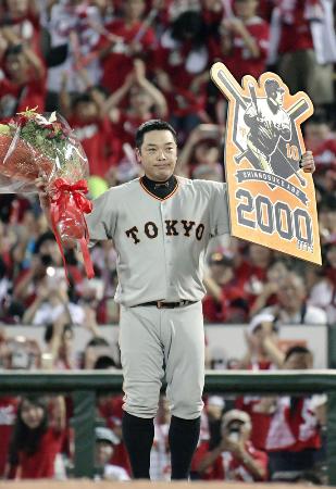 プロ野球広島戦で通算2千安打を達成し、ボードを掲げる巨人の阿部慎之助内野手=13日、広島市のマツダスタジアム