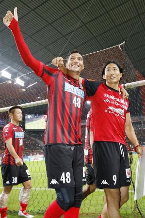 第19節で浦和を破り、サポーターの声援に応える札幌のジェイ(左)と都倉。残留を目指すチームの攻撃を引っ張る=札幌ドーム