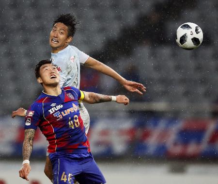 FC東京―札幌 後半、ヘディングでシュートを放つ札幌・都倉(奥)=味スタ
