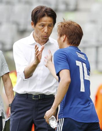 日本―パラグアイ 後半、勝ち越しゴールを決めた乾(右)とタッチする西野監督=インスブルック(共同)