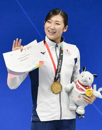 ジャカルタ・アジア大会の女子50メートル自由形で優勝し、表彰台で手を振る池江璃花子。6冠を達成した=ジャカルタ(共同)