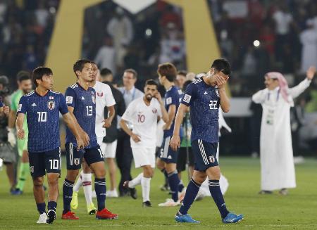 カタールに敗れ、手で顔を覆う吉田(手前右)ら=アブダビ(共同)