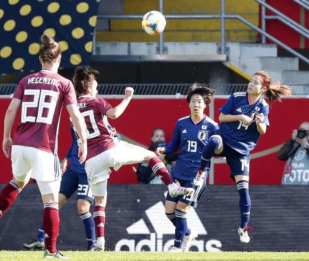 女子国際親善試合、日本―ドイツの前半、空中で競り合う長谷川(右端)=パーダーボルン(共同)