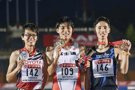 日本選手権の男子5000メートルで優勝し、表彰台でメダルを掲げる松枝博輝(中央)。左は2位の田中秀幸、右は3位の服部弾馬=博多の森陸上競技場
