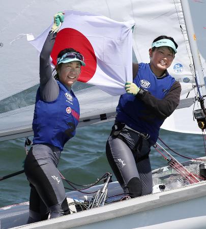 セーリングの世界選手権女子470級で2位となり、日の丸を掲げ喜ぶ吉田愛(左)、吉岡美帆組=2019年8月9日、神奈川県江の島ヨットハーバー沖