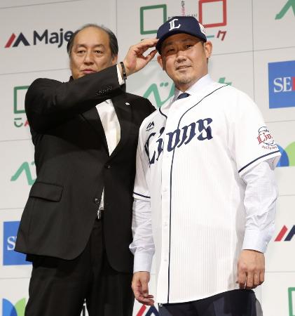 西武の入団会見終了後、渡辺GM(左)に帽子をかぶせてもらう松坂大輔投手=12月11日、東京都内のホテル