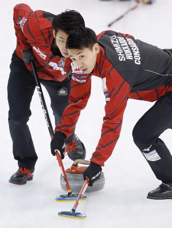 カーリング日本選手権の決勝でTM軽井沢と対戦し、スイープするコンサドーレの清水(右)と谷田=軽井沢アイスパーク