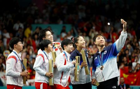 韓国選手(右の2人)の自撮りに応じる北朝鮮のリ・ジョンシク(左端)とキム・グムヨン(左から2番目)=30日、パリ(ロイター=共同)
