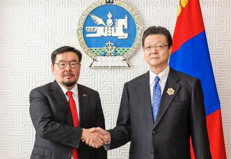 モンゴル政府から「北極星勲章」を授与され政府関係者(左)と握手する大相撲の伊勢ケ浜親方=15日、ウランバートル(モンゴル大統領府提供・共同)