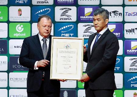 山下泰裕氏がIJFから名誉委員の称号を授与され、世界選手権会場でセレモニーに参加した井上康生氏(右)=19日、ブダペスト(共同)