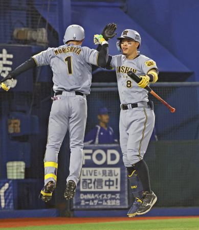 ８回、この試合２本目となる本塁打を放った森下（左）を迎える阪神・佐藤輝＝横浜 