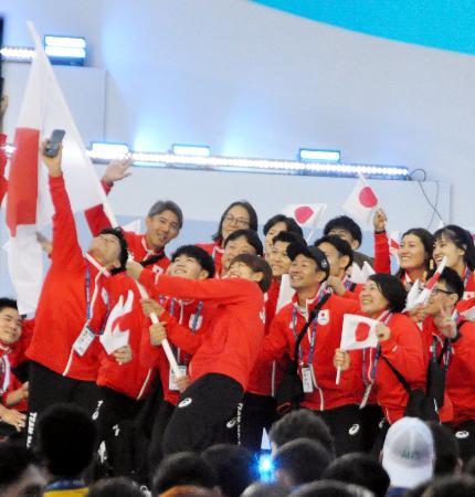 世界ユニバーシティー夏季大会の開会式で、行進中に写真撮影をする日本選手団=デュイスブルク(共同)