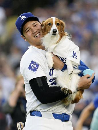 昨年8月、米大リーグのオリオールズ戦で「始球式」を行った愛犬デコピンと笑顔のドジャース・大谷翔平=ロサンゼルス