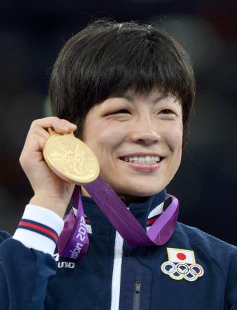 ロンドン五輪女子48キロ級で獲得した金メダルを手に笑顔を見せる小原日登美さん=2012年8月、エクセル(共同)