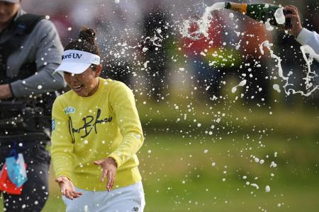 全英女子オープンで初優勝し、祝福のシャンパンシャワーを浴びる山下美夢有=3日、ポースコール(AP=共同)
