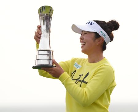 通算11アンダーでAIG全英女子オープンを制し、笑顔でトロフィーを掲げる山下美夢有=ロイヤルポースコールGC(共同)