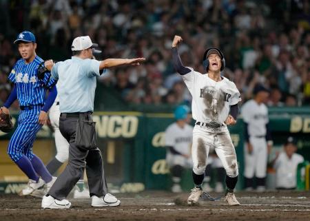 青藍泰斗―佐賀北 タイブレークの10回裏、山下のスクイズで生還し、喜ぶ佐賀北の三走塚原。左は青藍泰斗・永井=甲子園