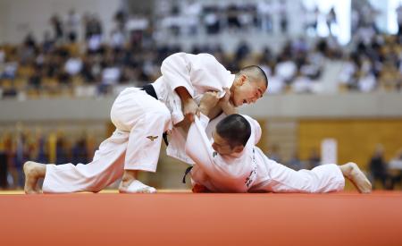 男子６６キロ級決勝で、足立学園・嶋貫蓮（右）を攻める佐賀商・田中龍希＝ジップアリーナ岡山 