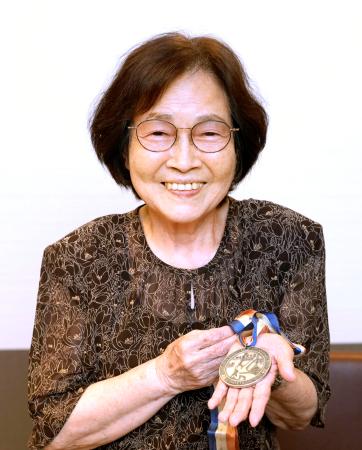 デフリンピックの1965年ワシントン大会卓球で獲得した銀メダルを手にする鈴木リヲ子さん=5日、東京都東大和市